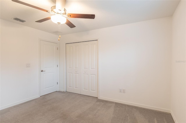 unfurnished bedroom with light carpet, baseboards, visible vents, ceiling fan, and a closet