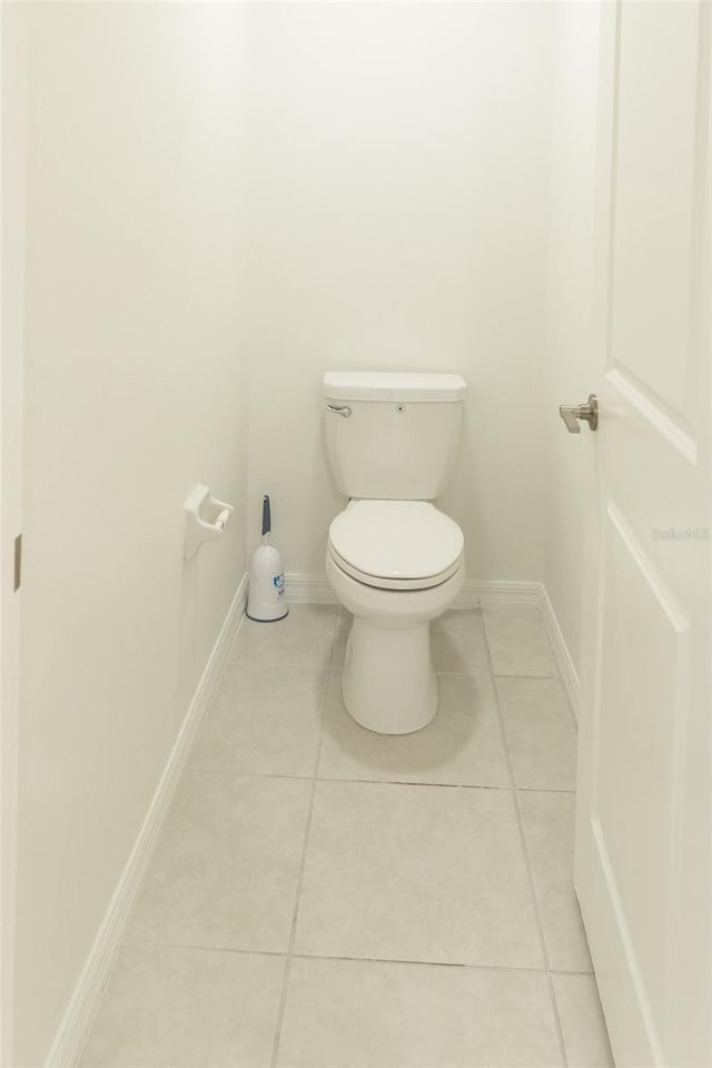 bathroom featuring baseboards, toilet, and tile patterned floors