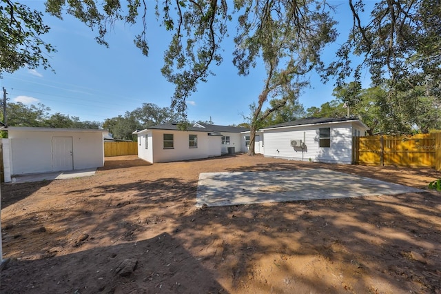 back of house with an outdoor structure and a patio area