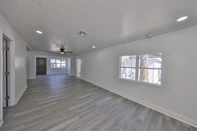 spare room with ceiling fan, light hardwood / wood-style flooring, and a textured ceiling