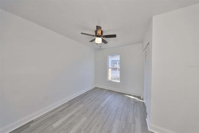 unfurnished room featuring a textured ceiling, ceiling fan, and light wood-type flooring