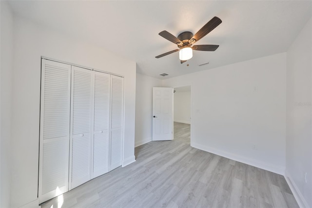 unfurnished bedroom with ceiling fan, light hardwood / wood-style floors, and a closet