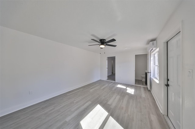 unfurnished bedroom featuring an AC wall unit, ceiling fan, and light hardwood / wood-style flooring