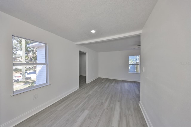 unfurnished room featuring light hardwood / wood-style flooring and a textured ceiling