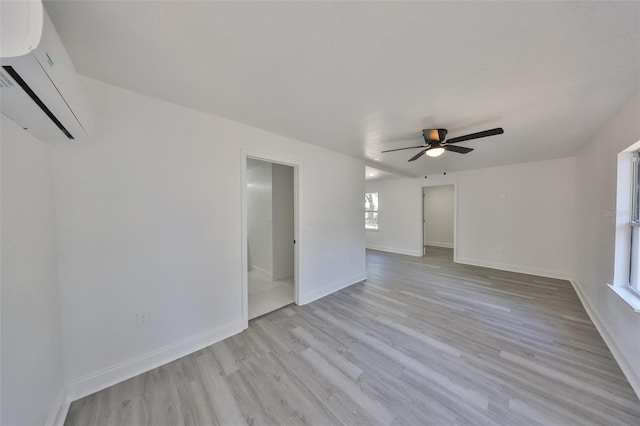 unfurnished room featuring ceiling fan, a wall unit AC, and light hardwood / wood-style flooring