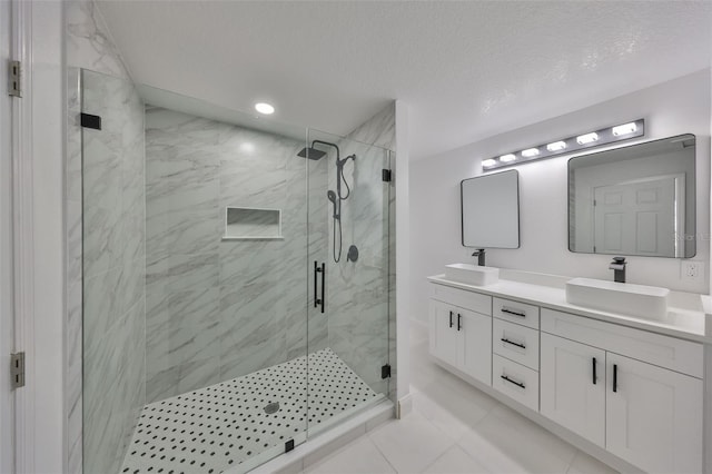 bathroom featuring vanity, a shower with shower door, and a textured ceiling