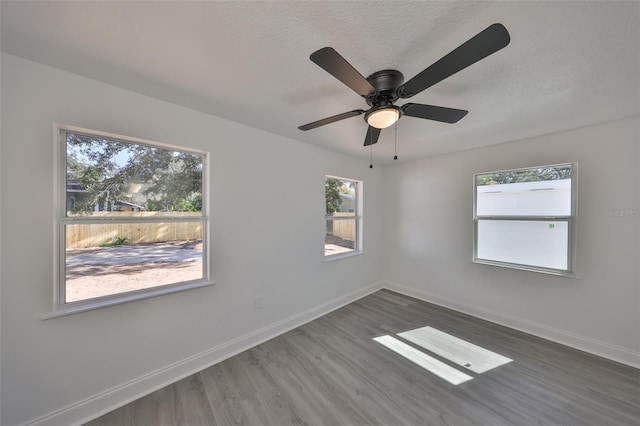 spare room featuring ceiling fan, dark hardwood / wood-style floors, and a textured ceiling