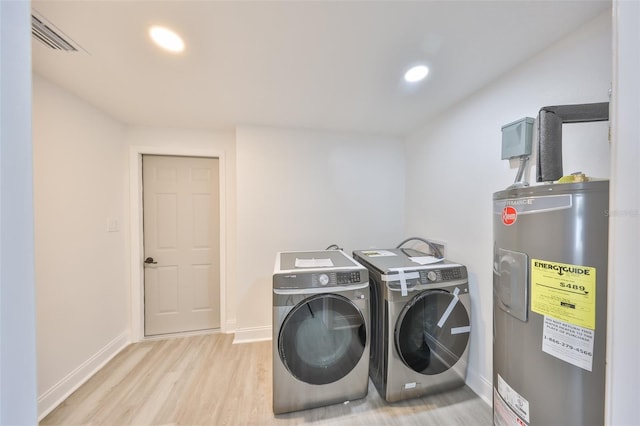 laundry room with washer and dryer, electric water heater, and light hardwood / wood-style flooring