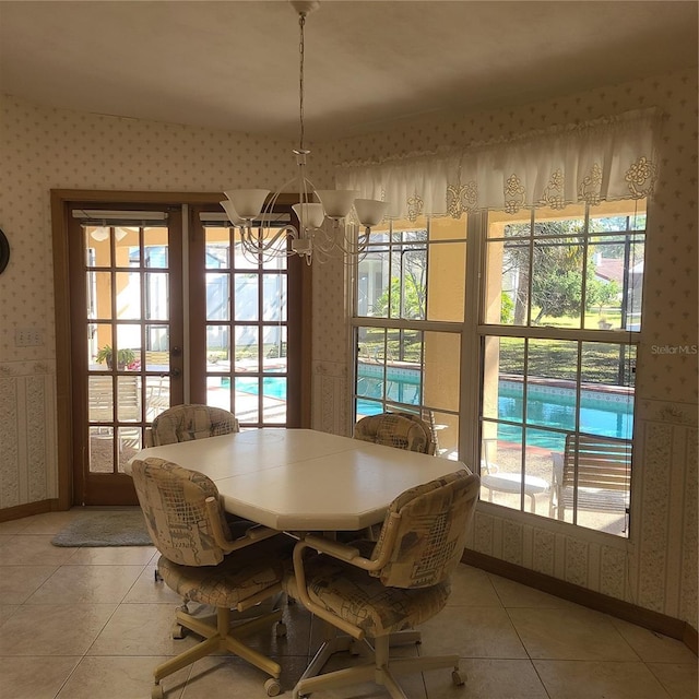 dining space featuring lofted ceiling, light tile patterned floors, and an inviting chandelier