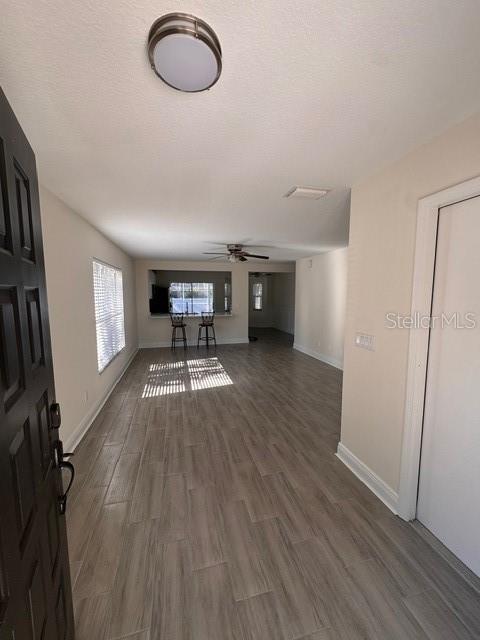 interior space featuring a textured ceiling, ceiling fan, and dark hardwood / wood-style floors