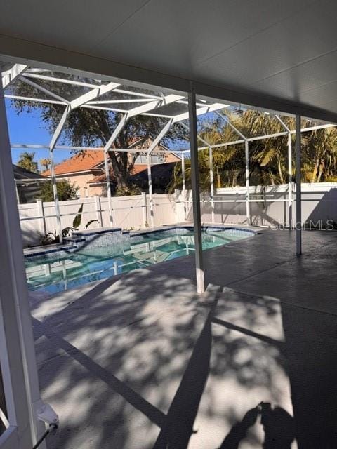 view of swimming pool with a patio and glass enclosure