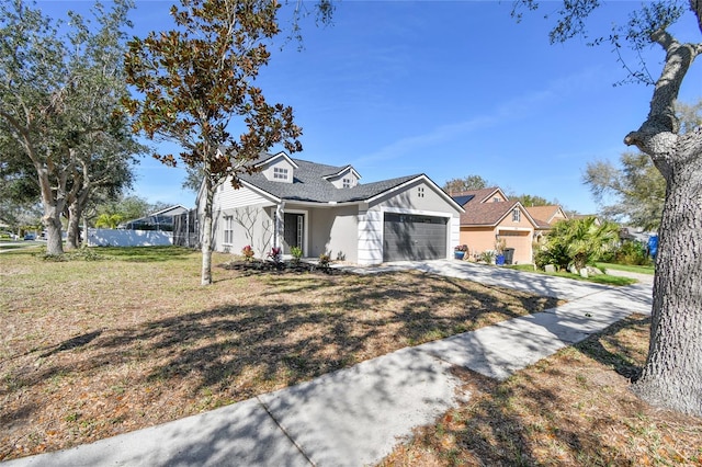 view of front facade with a garage, a front lawn, and concrete driveway