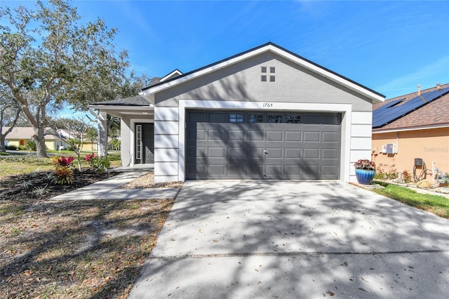 view of front of house featuring a garage, driveway, and stucco siding