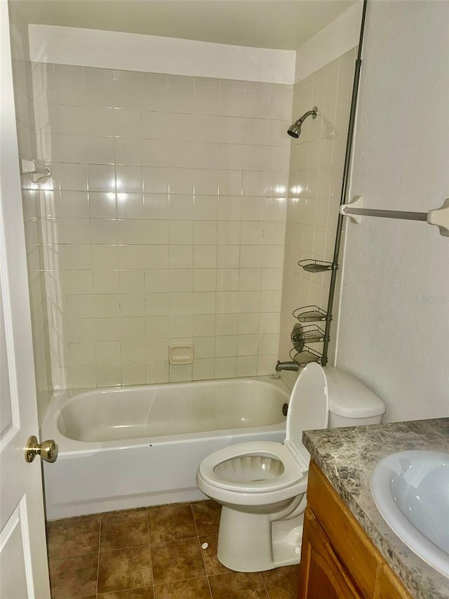 full bathroom with tile patterned floors, toilet, tiled shower / bath combo, and vanity