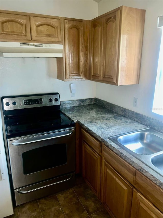 kitchen featuring dark tile patterned floors, sink, and electric range