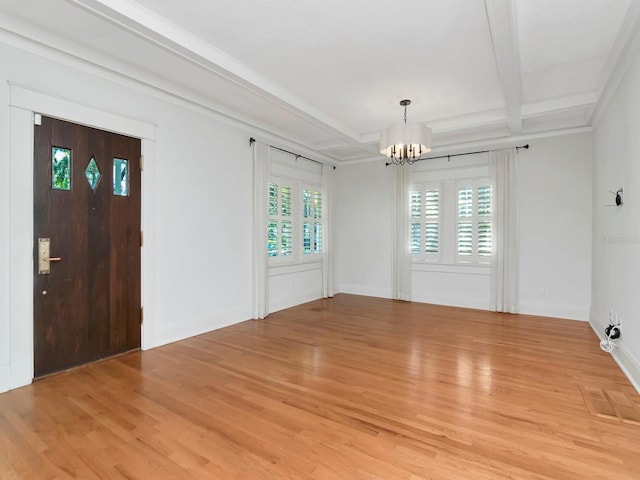 foyer entrance featuring beam ceiling, a chandelier, and light hardwood / wood-style flooring