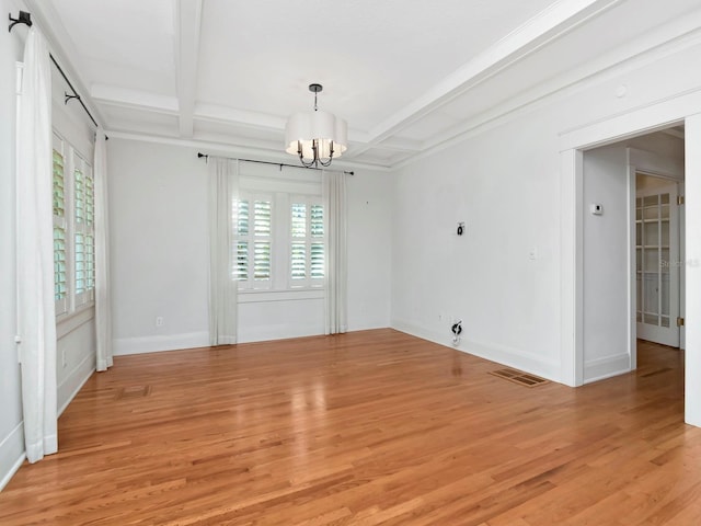 empty room featuring coffered ceiling, beam ceiling, a chandelier, and light wood-type flooring