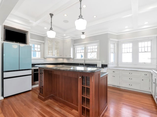 kitchen featuring pendant lighting, light hardwood / wood-style flooring, coffered ceiling, white cabinets, and a kitchen island