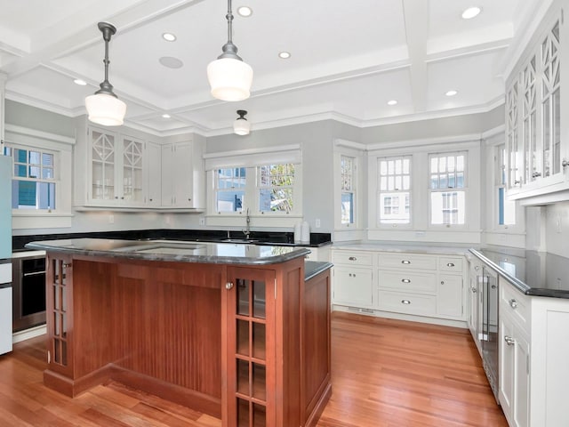 kitchen with white cabinetry, hanging light fixtures, coffered ceiling, a kitchen island, and light wood-type flooring