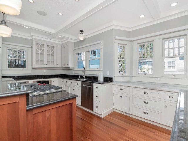 kitchen featuring beamed ceiling, appliances with stainless steel finishes, sink, and white cabinets