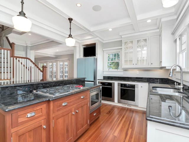 kitchen with white cabinetry, hanging light fixtures, and appliances with stainless steel finishes