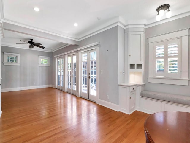 unfurnished living room with crown molding, ceiling fan, and light hardwood / wood-style floors