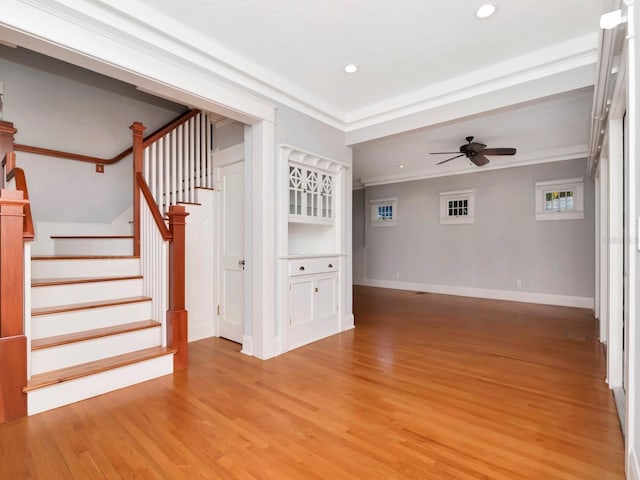 unfurnished living room featuring hardwood / wood-style flooring, crown molding, and ceiling fan