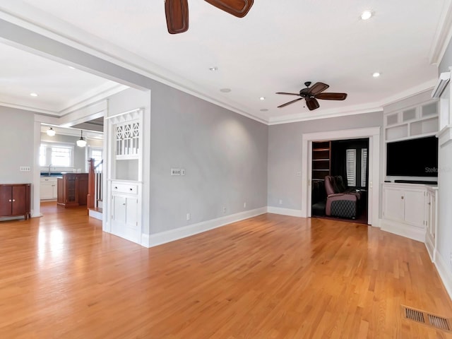 unfurnished living room featuring crown molding, ceiling fan, and light wood-type flooring