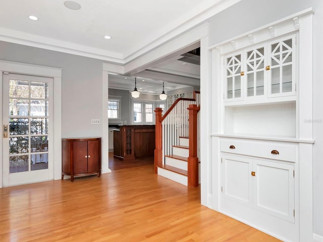 interior space with ornamental molding and hardwood / wood-style floors