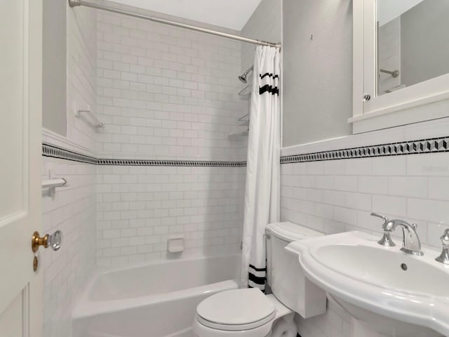 full bathroom with tile walls, sink, shower / bath combination with curtain, and toilet