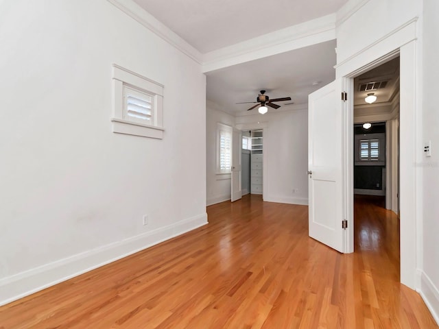 unfurnished living room featuring ceiling fan, ornamental molding, and light wood-type flooring