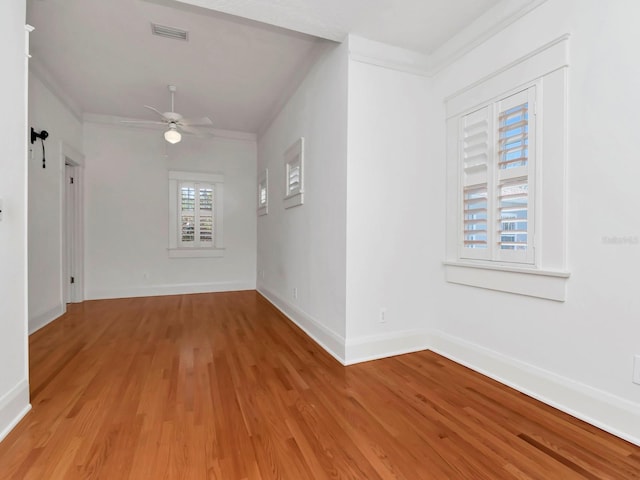 unfurnished room with crown molding, ceiling fan, and light wood-type flooring