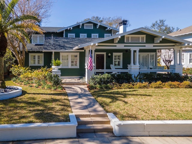 craftsman-style house featuring covered porch and a front lawn