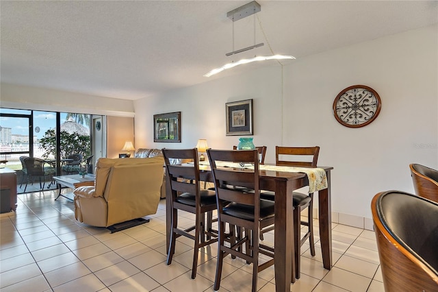 dining space featuring light tile patterned floors and a textured ceiling