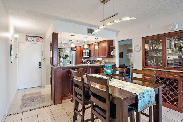 tiled dining space featuring a textured ceiling