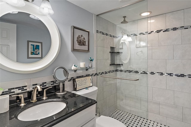 bathroom featuring tasteful backsplash, vanity, toilet, and tiled shower