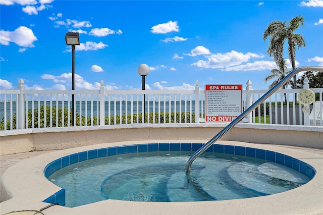 view of pool featuring a water view and a community hot tub