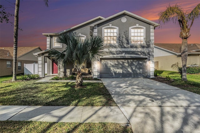 view of front of house with a garage and a lawn