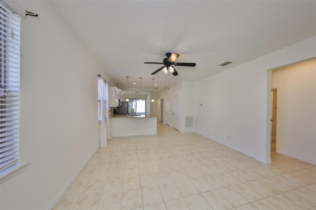 unfurnished living room with ceiling fan and light tile patterned flooring