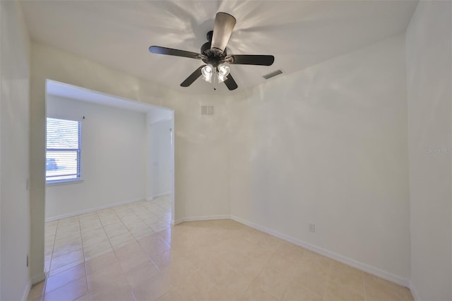 tiled empty room featuring ceiling fan