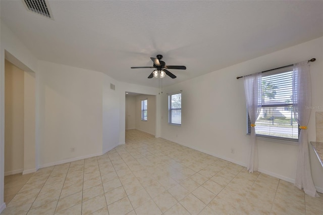 tiled empty room featuring ceiling fan