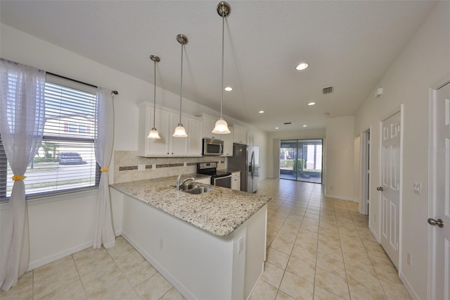 kitchen with white cabinetry, sink, hanging light fixtures, kitchen peninsula, and stainless steel appliances