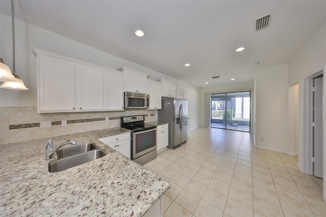 kitchen featuring sink, appliances with stainless steel finishes, light stone countertops, decorative backsplash, and white cabinets