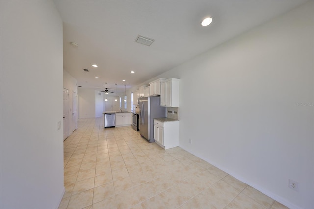 kitchen featuring light tile patterned floors, ceiling fan, appliances with stainless steel finishes, white cabinetry, and decorative light fixtures