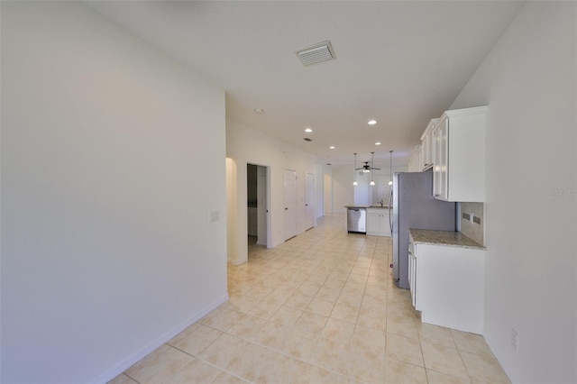 kitchen with white cabinetry, appliances with stainless steel finishes, pendant lighting, ceiling fan, and light stone countertops