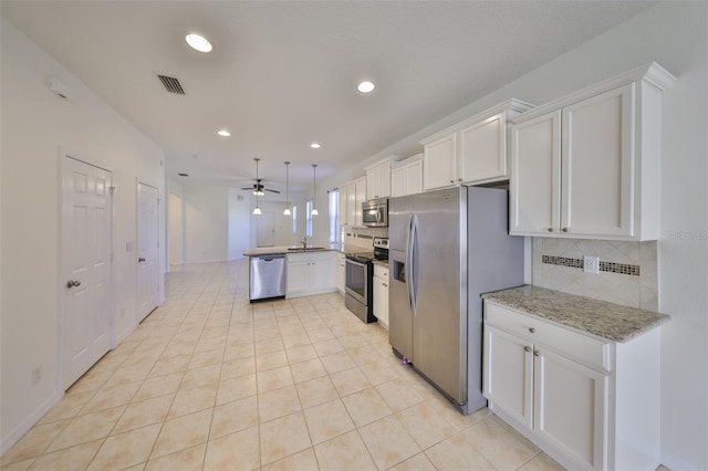 kitchen featuring light stone counters, appliances with stainless steel finishes, sink, and white cabinets