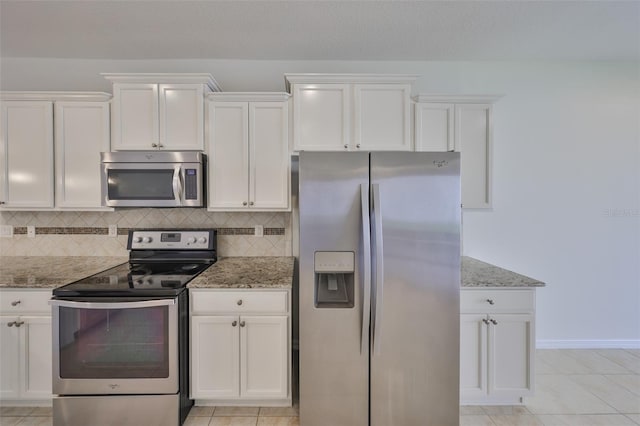 kitchen featuring light stone counters, white cabinetry, and stainless steel appliances