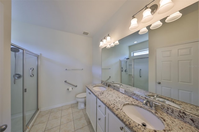 bathroom featuring tile patterned flooring, vanity, a shower with shower door, and toilet