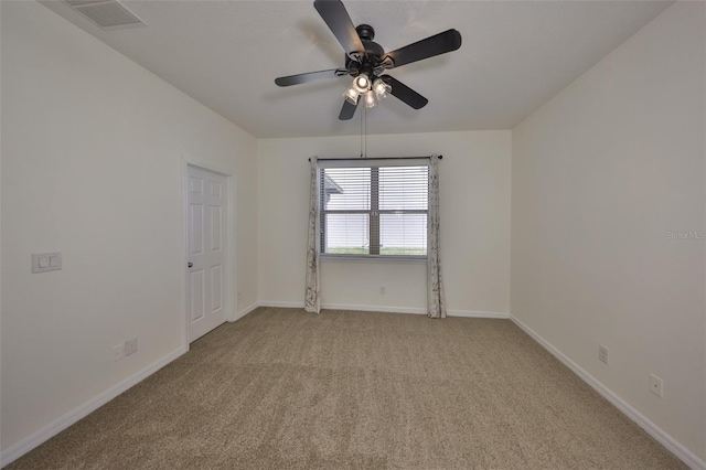 carpeted spare room featuring ceiling fan