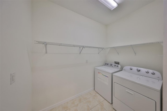 laundry room featuring washing machine and dryer and light tile patterned floors